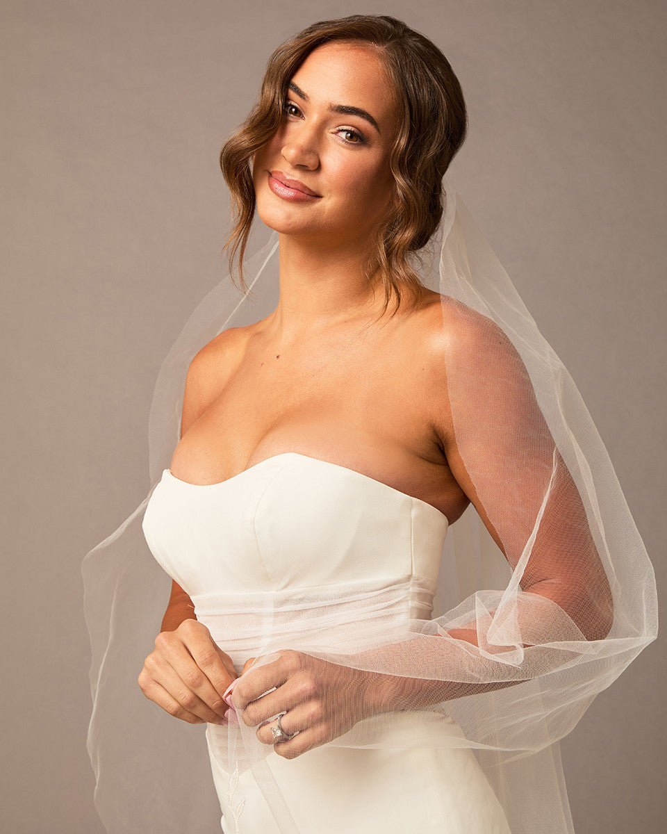  Lace Beaded Waltz Mantilla Wedding Veil Woman wearing a strapless white wedding dress with a sheer veil against a neutral background