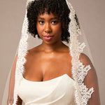 Woman wearing a white wedding dress with a lace veil against a neutral background Royal Cathedral Mantilla Veil with Wide Chantilly Lace