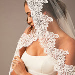 Bride wearing a lace veil against a neutral background Fingertip Mantilla Veil with Wide Chantilly Lace