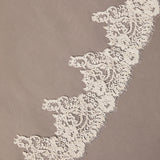 Close-up of intricate lace trim on a beige background Royal Cathedral Mantilla Veil with Wide Chantilly Lace