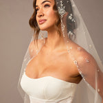 Fingertip Mantilla Veil with Pearl Clusters and Scatter Woman wearing a wedding dress with a decorative veil against a neutral background