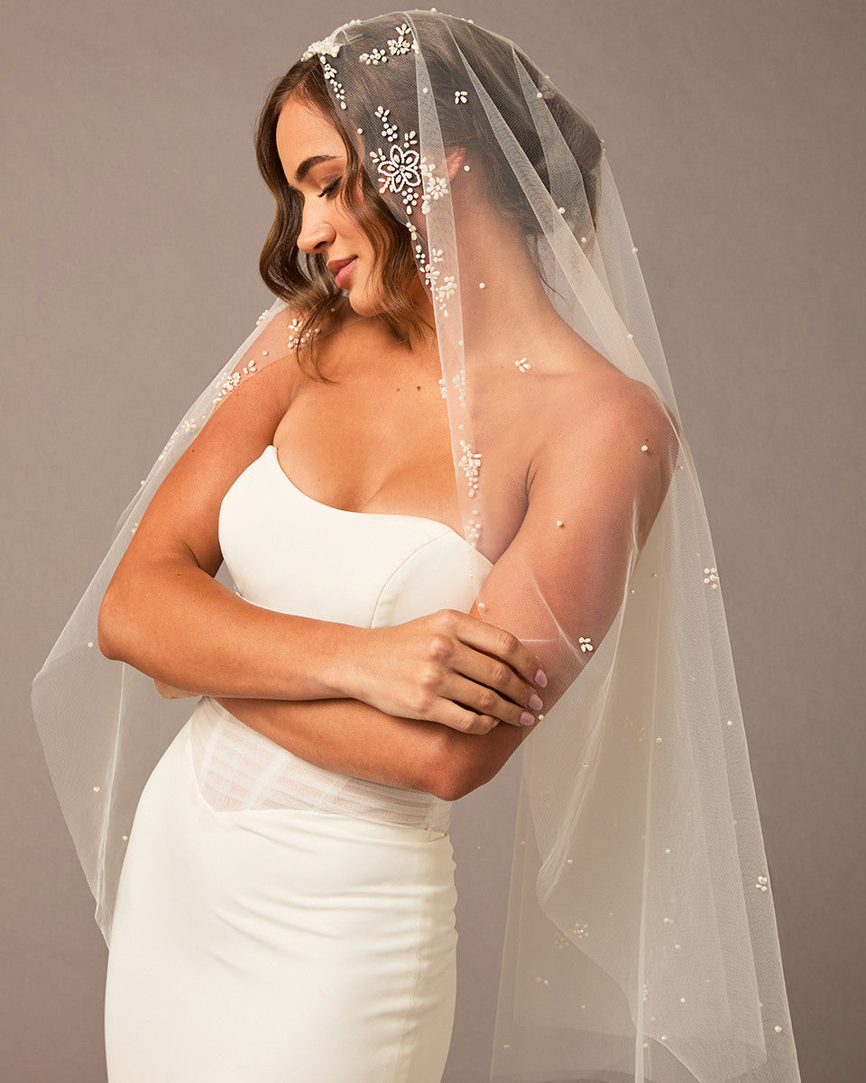 Fingertip Mantilla Veil with Pearl Clusters and Scatter Woman wearing a wedding dress with an embellished veil against a neutral background