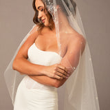 Fingertip Mantilla Veil with Pearl Clusters and Scatter Woman wearing a wedding dress with an embellished veil against a neutral background