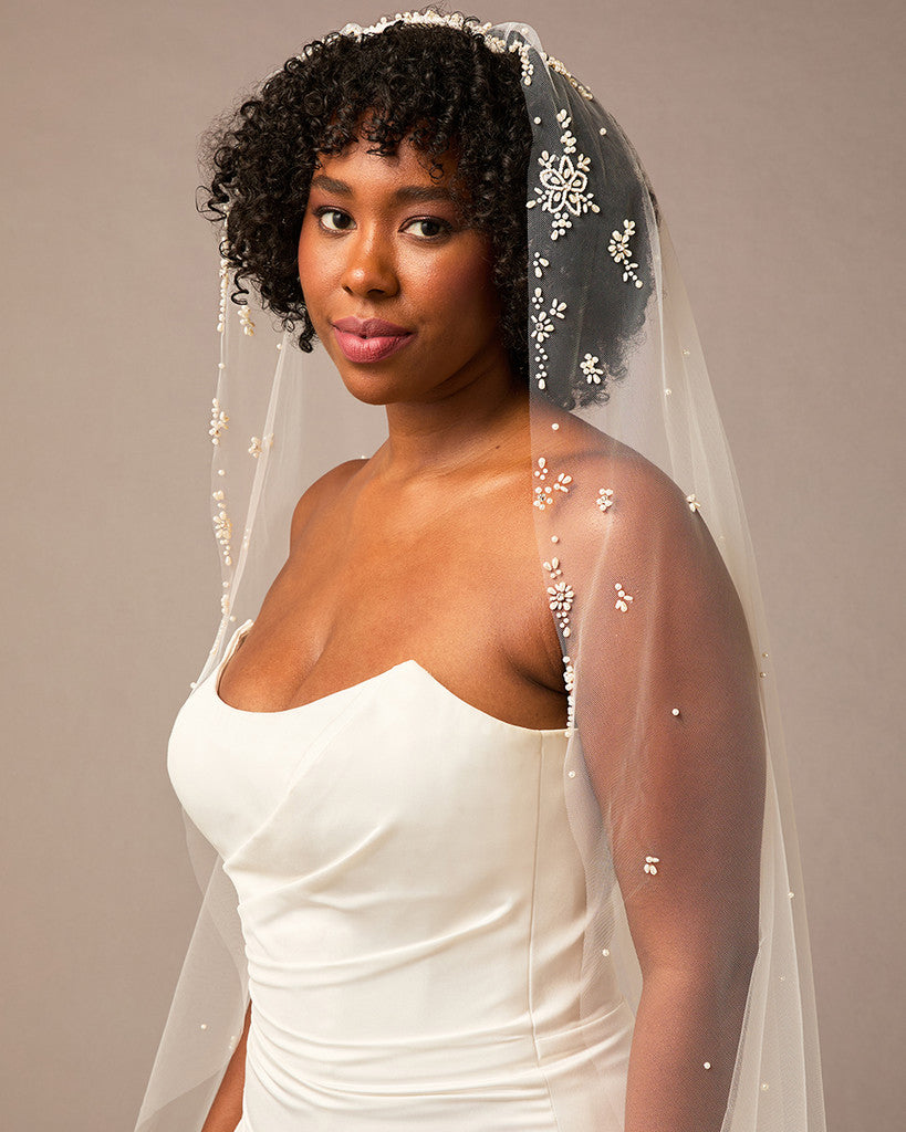 Royal Mantilla Veil with Pearl Clusters and Scatter Woman wearing a wedding dress with a veil against a neutral background