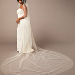 Royal Mantilla Veil with Pearl Clusters and Scatter Woman wearing a wedding dress with a long veil on a plain background