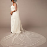 Royal Mantilla Veil with Pearl Clusters and Scatter Woman wearing a wedding dress with a long veil on a plain background