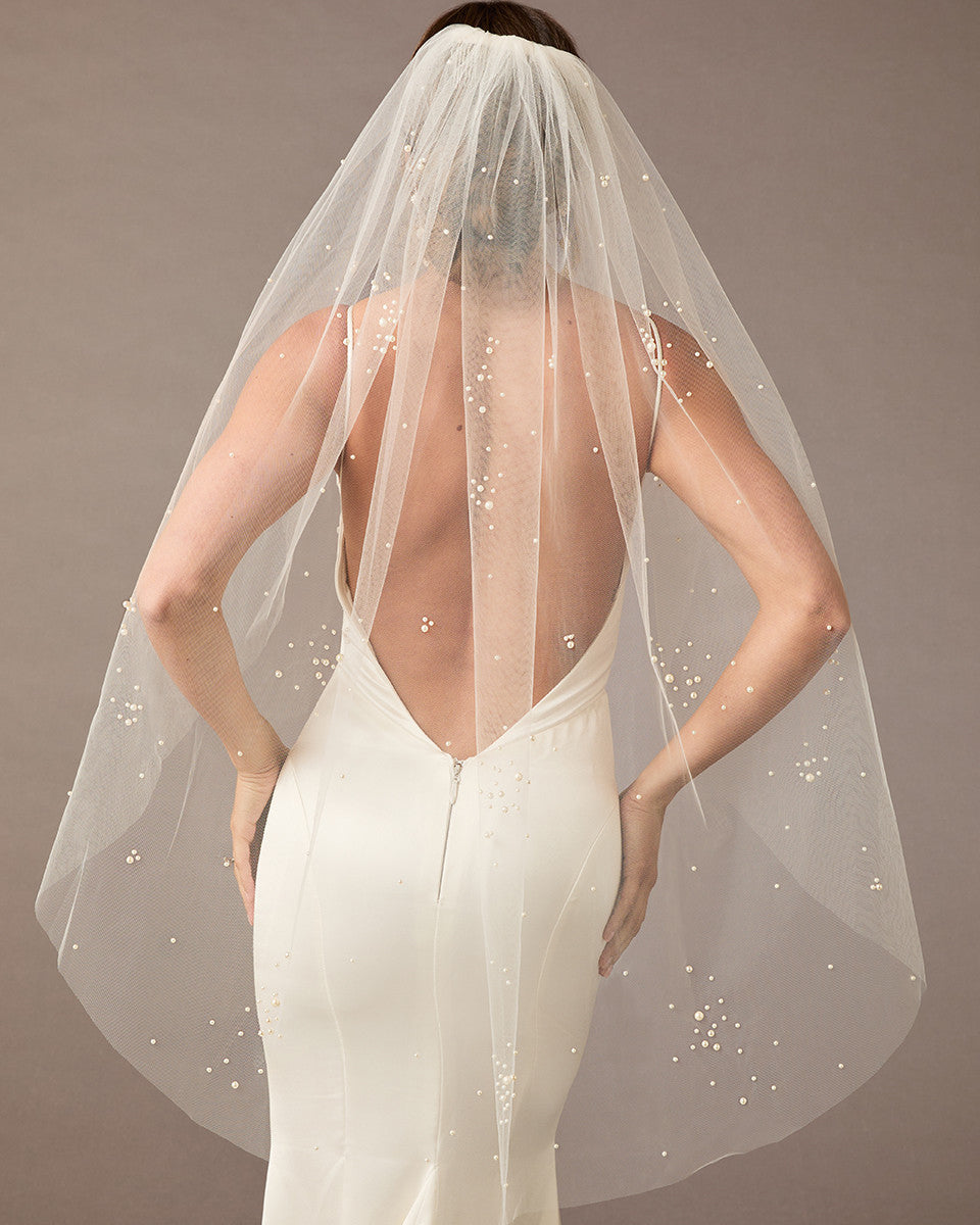 Fingertip Veil with Scattered Dense Pearl Clusters wedding dress with a sheer veil on a plain background