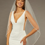 Metal Flower and Beads Fingertip Bridal Veil Woman wearing a  wedding dress with a sheer veil against a neutral background