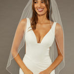 Bridal Veil with Crystal Beads and Pearls Woman wearing a wedding dress with a veil against a neutral background
