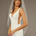 Bridal Veil with Crystal Beads and Pearls Woman wearing a wedding dress with a sheer veil against a neutral background