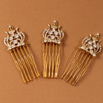 Regal Styled Small Wedding Hair Comb Three gold hair combs with ornate crystal-embellished crowns and long dangling strands, arranged on a warm brown background.