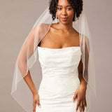 Fingertip Bridal Veil with Rhinestone Chain Trim Woman wearing a wedding dress with a sheer veil against a plain background