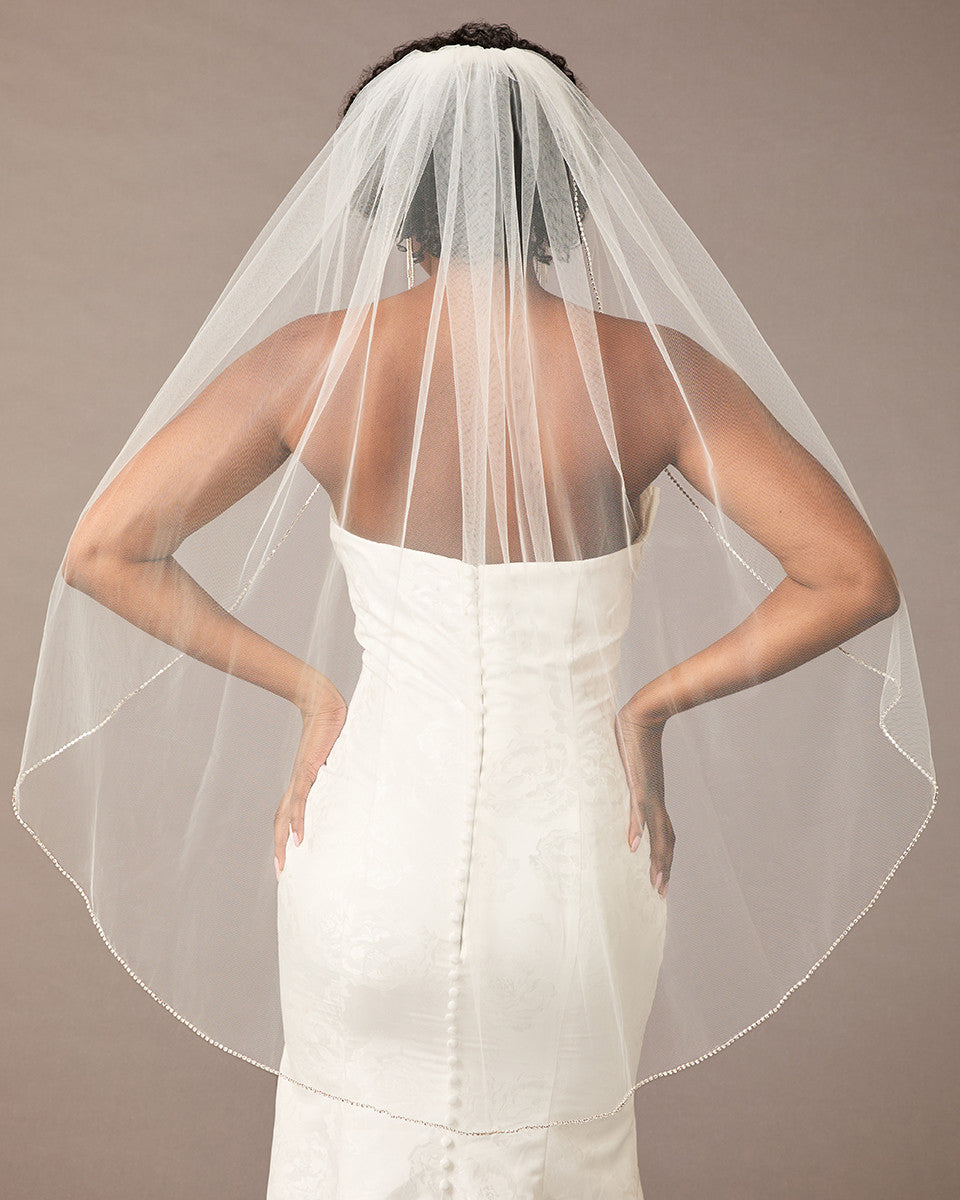 Fingertip Bridal Veil with Rhinestone Chain Trim Person wearing a wedding dress with a veil against a neutral background