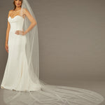 Cathedral Veil with Scattered Clusters of Crystal Beads Woman wearing a wedding dress with a long veil against a brown background