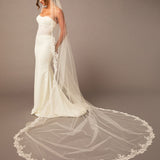 Partial Lace Trim Cathedral Bridal Veil Woman wearing a wedding dress with a long veil on a brown background