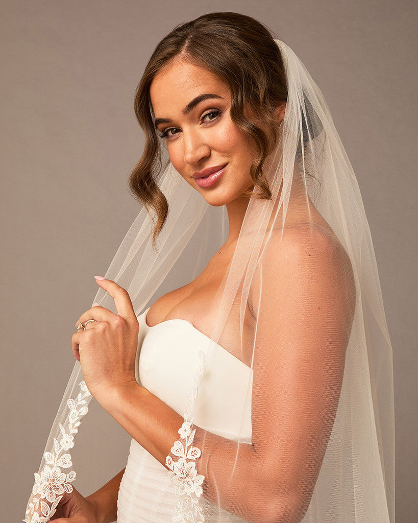 Partial Lace Trim Cathedral Bridal Veil Woman wearing a wedding dress with a veil against a neutral background