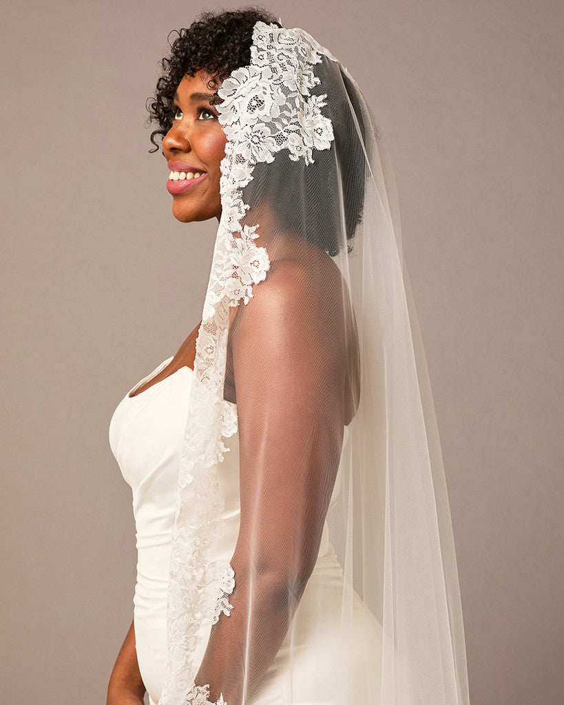 Bride wearing a white lace veil against a plain background Mantilla Cathedral Veil with Wide Flower Chantilly Lace