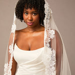 Woman wearing a white wedding dress with a lace veil against a neutral background Mantilla Cathedral Veil with Wide Flower Chantilly Lace