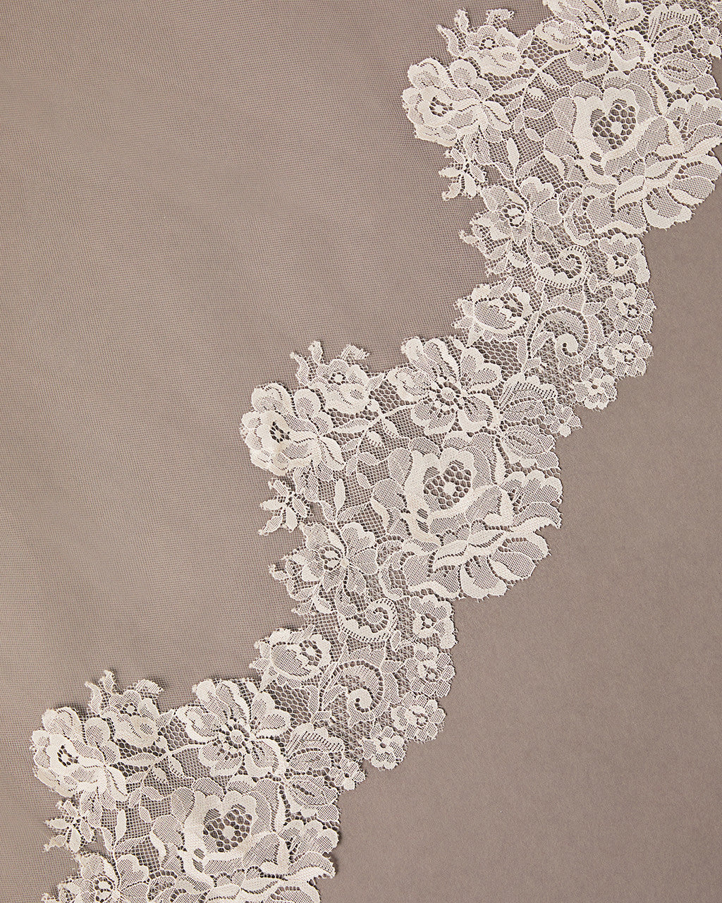 Close-up of floral lace trim on a beige background Mantilla Cathedral Veil with Wide Flower Chantilly Lace
