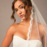 Bridal Veil with Scalloped Small Eyelash Lace Woman wearing a white strapless dress and veil against a neutral background