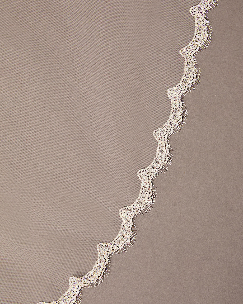 Bridal Veil with Scalloped Small Eyelash Lace Decorative lace trim on a beige background