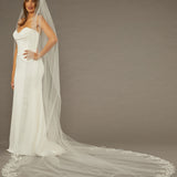 Cathedral Wedding Veil Finished Scallop Edge and Beads Woman wearing a wedding dress with a long veil against a brown background