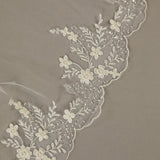 Cathedral Wedding Veil Finished Scallop Edge and Beads Close-up of lace fabric with floral patterns on a beige background