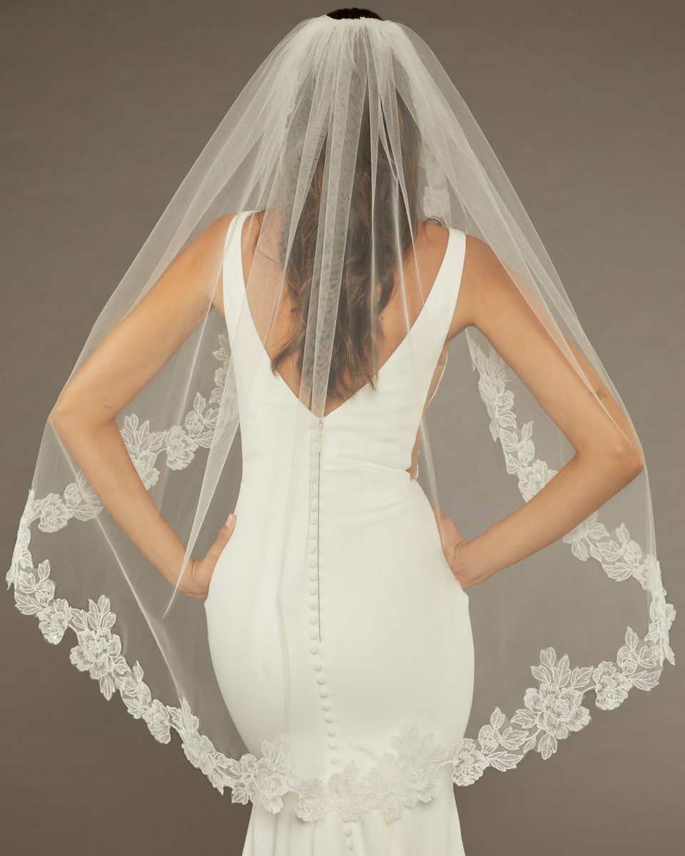 Sequined Lace Bridal Veil Fingertip Length Bride wearing a  wedding dress with a lace-trimmed veil against a dark background