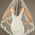 Sequined Lace Bridal Veil Fingertip Length Bride wearing a  wedding dress with a lace-trimmed veil against a dark background