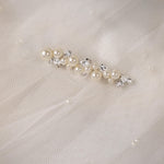 Bridal Bobby Pin with Ivory Pearls A pearl and crystal hair accessory displayed on a soft white tulle fabric background.