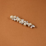 Bridal Bobby Pin with Ivory Pearls A pearl and crystal hair claw accessory with silver-toned metal, displayed on a textured brown background.
