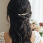 Bridal Bobby Pin with Ivory Pearls A woman shown from behind wearing a half-up hairstyle with a decorative hair accessory made of small white pearls and metallic beads, paired with a white lace top.