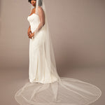 Zig Zag Teardrop Pearl Trimmed Cathedral Bridal Veil Woman wearing a wedding dress with a long veil on a plain background