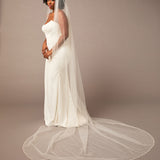 Zig Zag Teardrop Pearl Trimmed Cathedral Bridal Veil Woman wearing a wedding dress with a long veil on a plain background