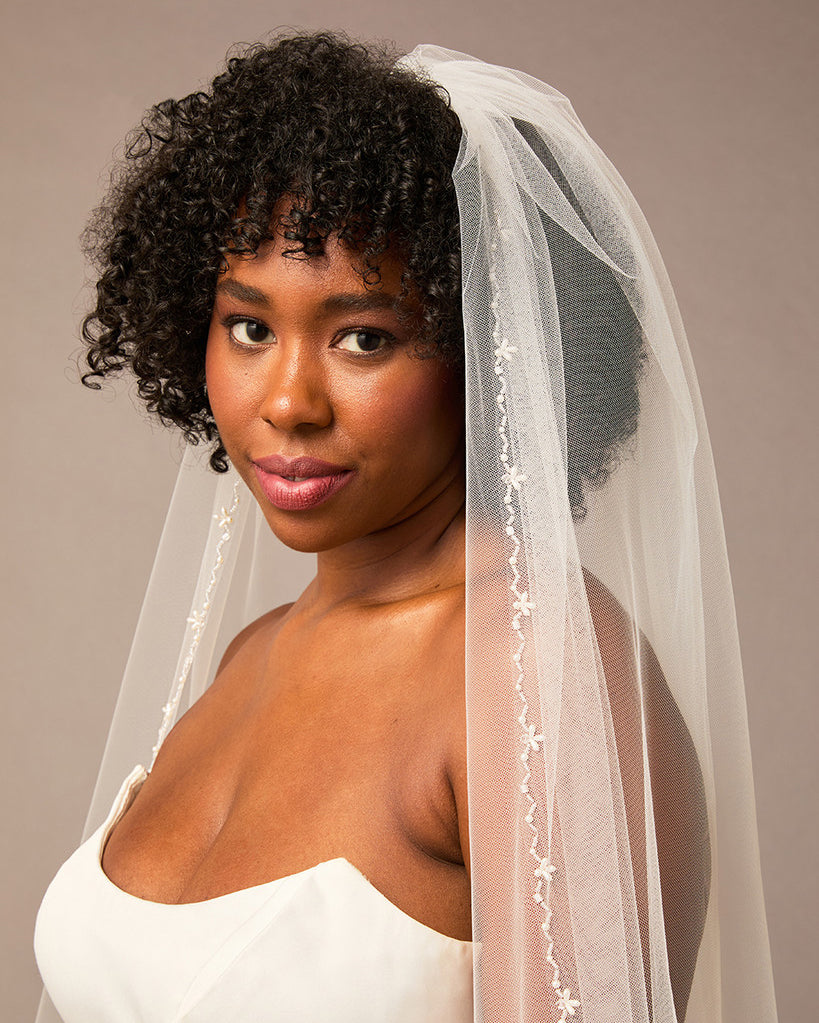 Zig Zag Teardrop Pearl Trimmed Cathedral Bridal Veil Woman wearing a wedding dress with a veil against a neutral background