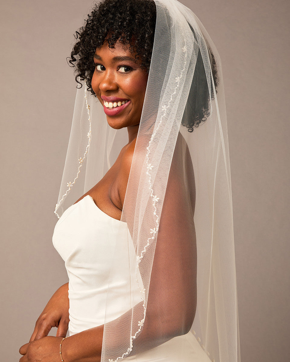 Zig Zag Teardrop Pearl Trimmed Bridal Veil Woman wearing a wedding dress with a veil against a plain background