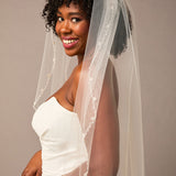 Zig Zag Teardrop Pearl Trimmed Bridal Veil Woman wearing a wedding dress with a veil against a plain background