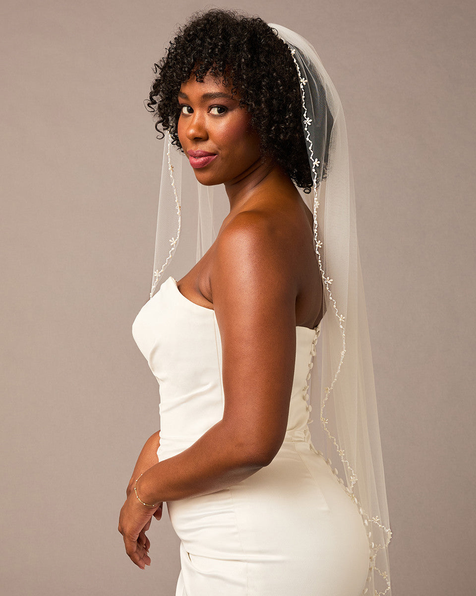 Zig Zag Teardrop Pearl Trimmed Bridal Veil Woman wearing a wedding dress with a veil against a plain background