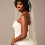 Zig Zag Teardrop Pearl Trimmed Bridal Veil Woman wearing a wedding dress with a veil against a plain background