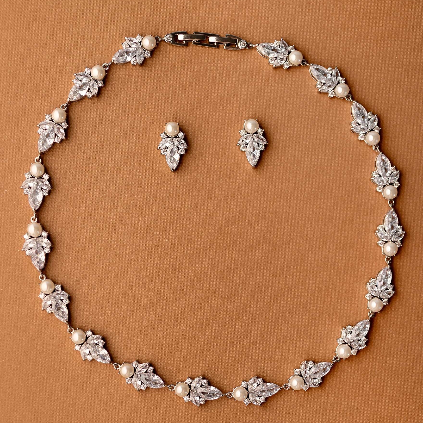 Jewelry set with necklace and earrings on a brown background