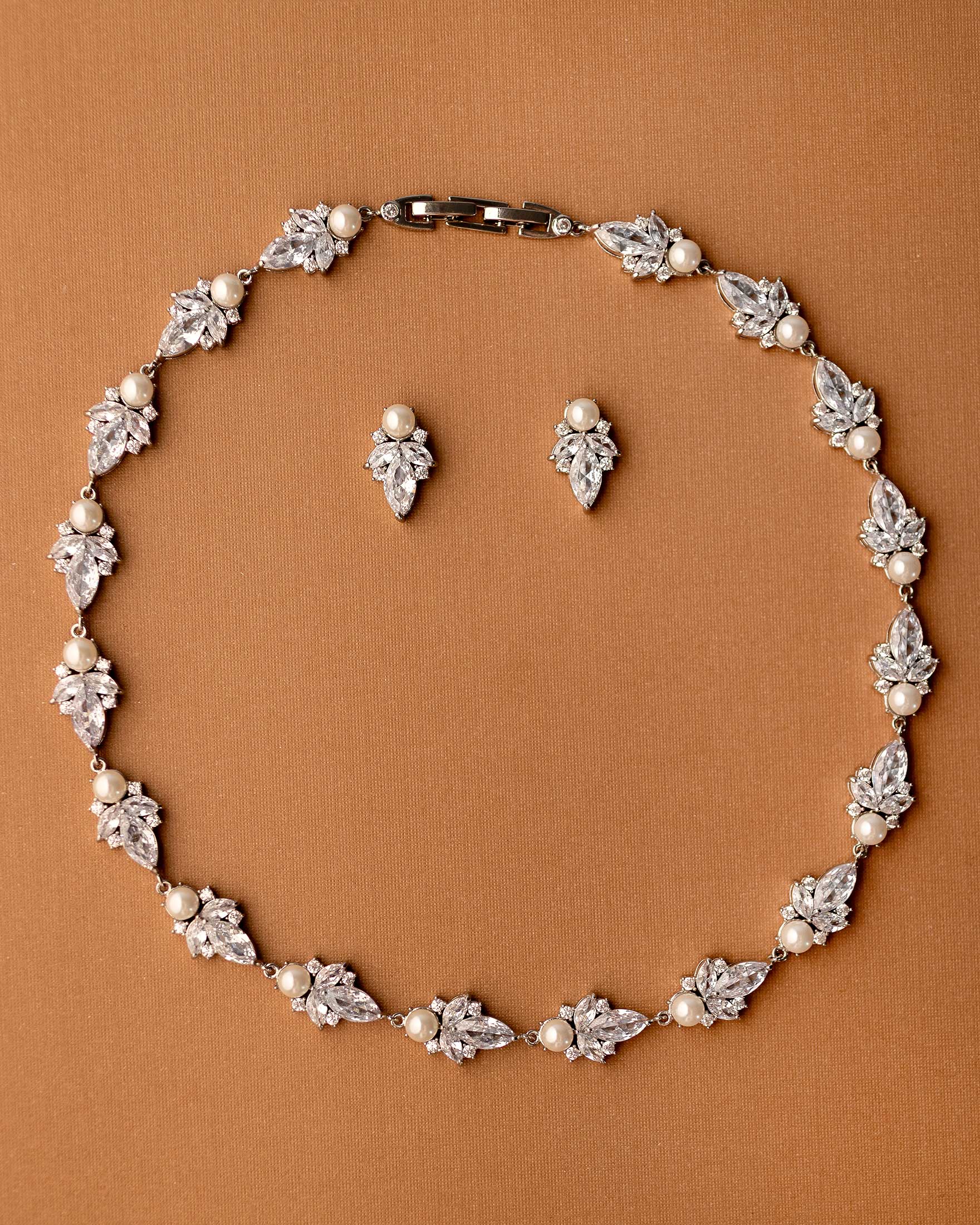 Jewelry set with necklace and earrings on a brown background