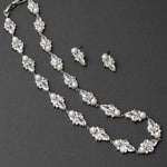 Pearl and crystal necklace with matching earrings on a dark background