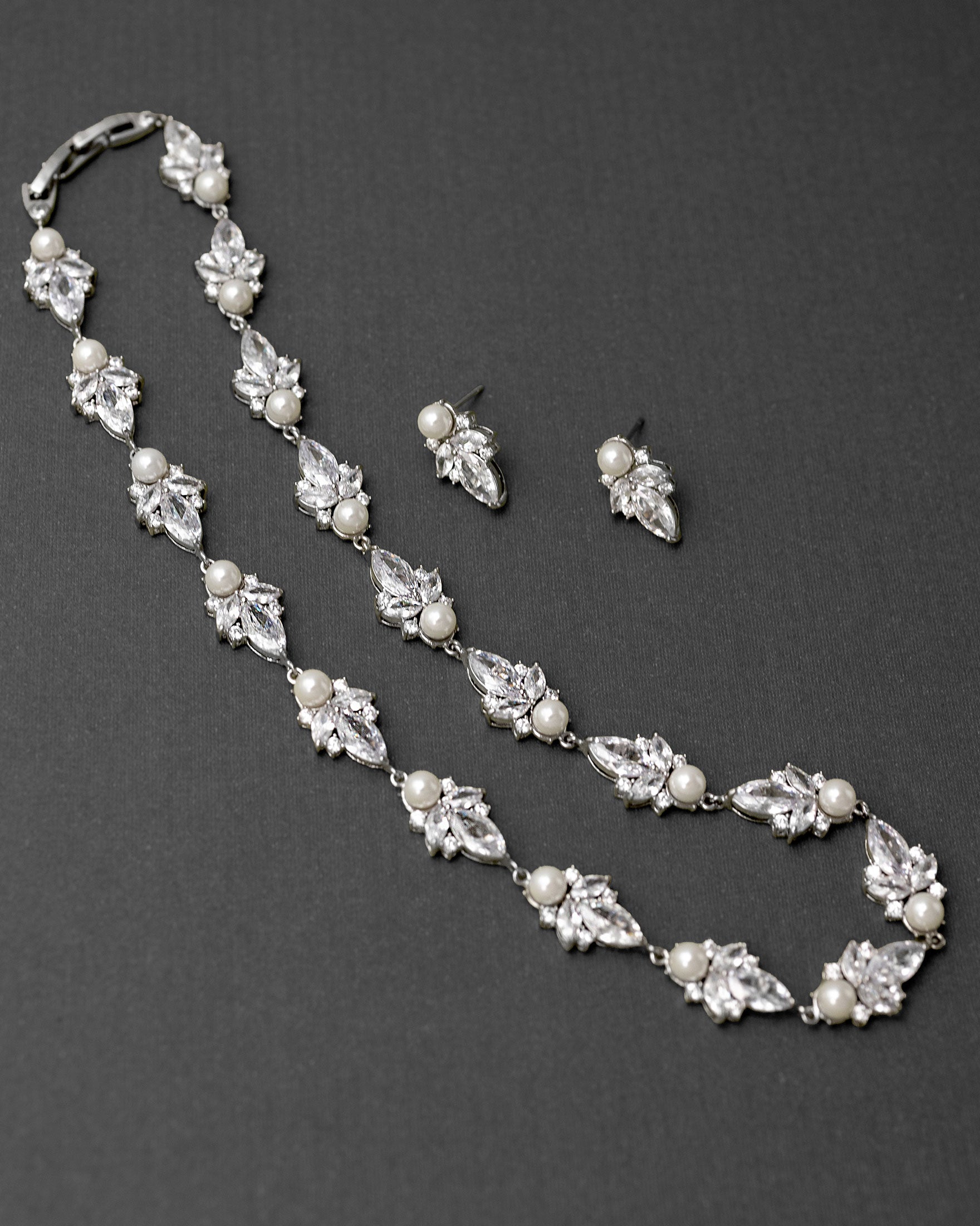 Pearl and crystal necklace with matching earrings on a dark background