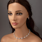Mannequin head with a cz necklace and earrings on a gray background