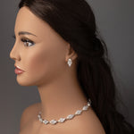 Mannequin head with jewelry including a necklace and earrings on a gray background