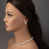 Mannequin head with jewelry including a necklace and earrings on a gray background
