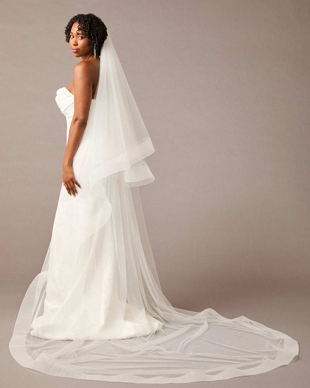 Royal Cathedral Horsehair Trim Two Layer Veil 3 inch ribbon Woman wearing a wedding dress with a long veil against a plain background