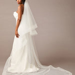 Royal Cathedral Horsehair Trim Two Layer Veil 3 inch ribbon Woman wearing a wedding dress with a long veil against a plain background