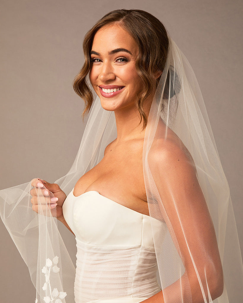 Clover Cut Regal Cathedral Veil with Organza Vines Woman wearing a  wedding dress with a veil against a neutral background