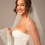 Clover Cut Regal Cathedral Veil with Organza Vines Woman wearing a  wedding dress with a veil against a neutral background